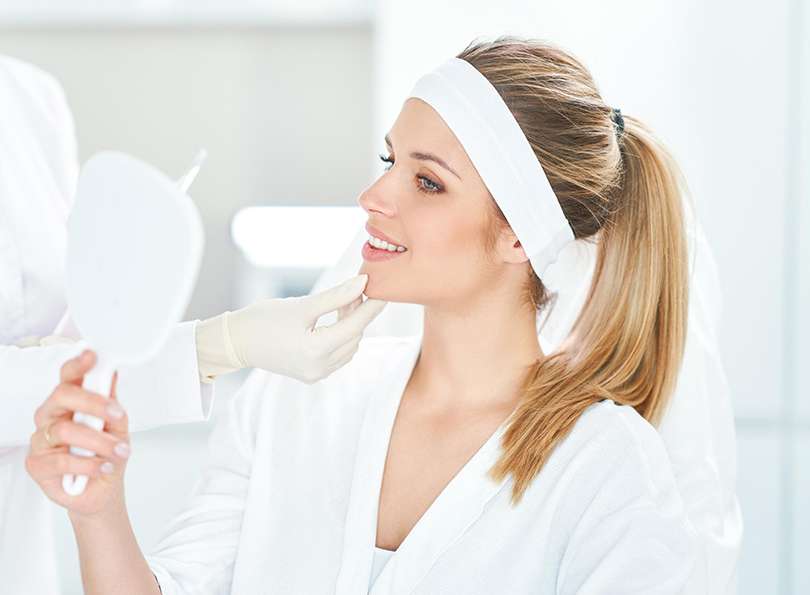 woman looking in the mirror after botox treatment